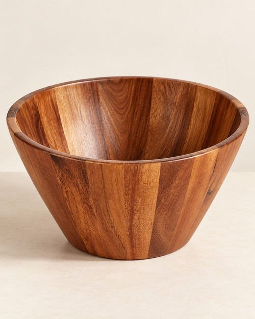 Empty acacia wood salad bowl on a warm off-white surface.