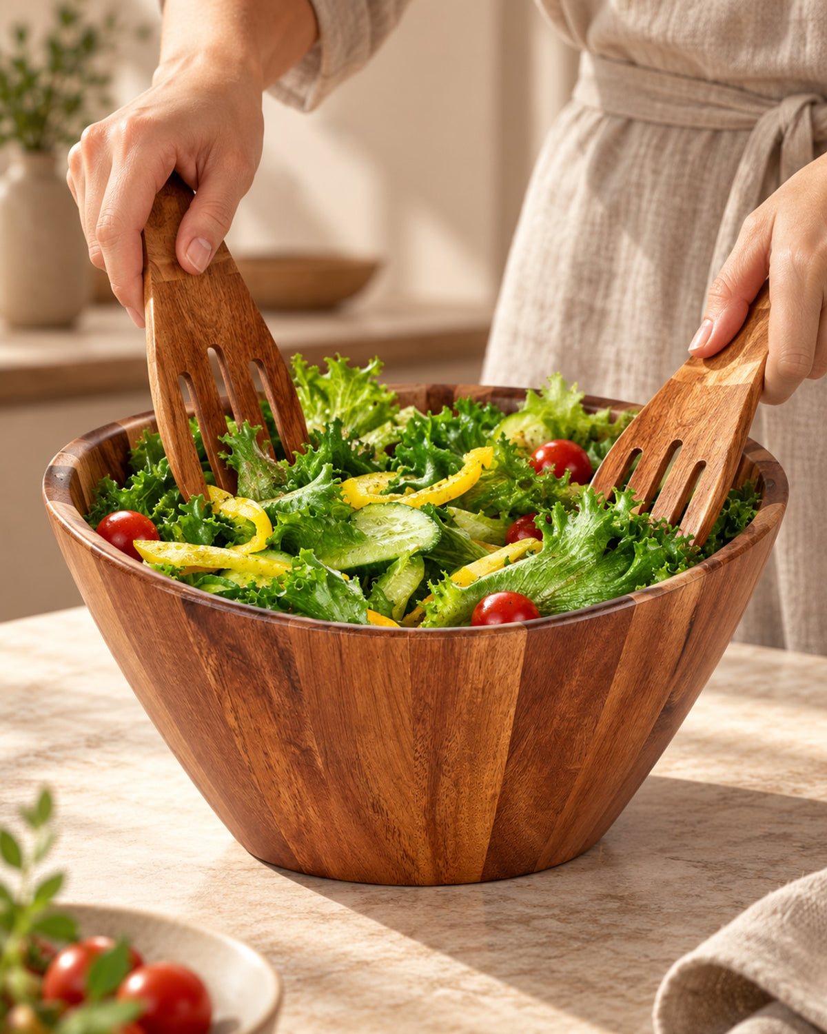 Hands tossing salad in the acacia bowl. Servers not included.