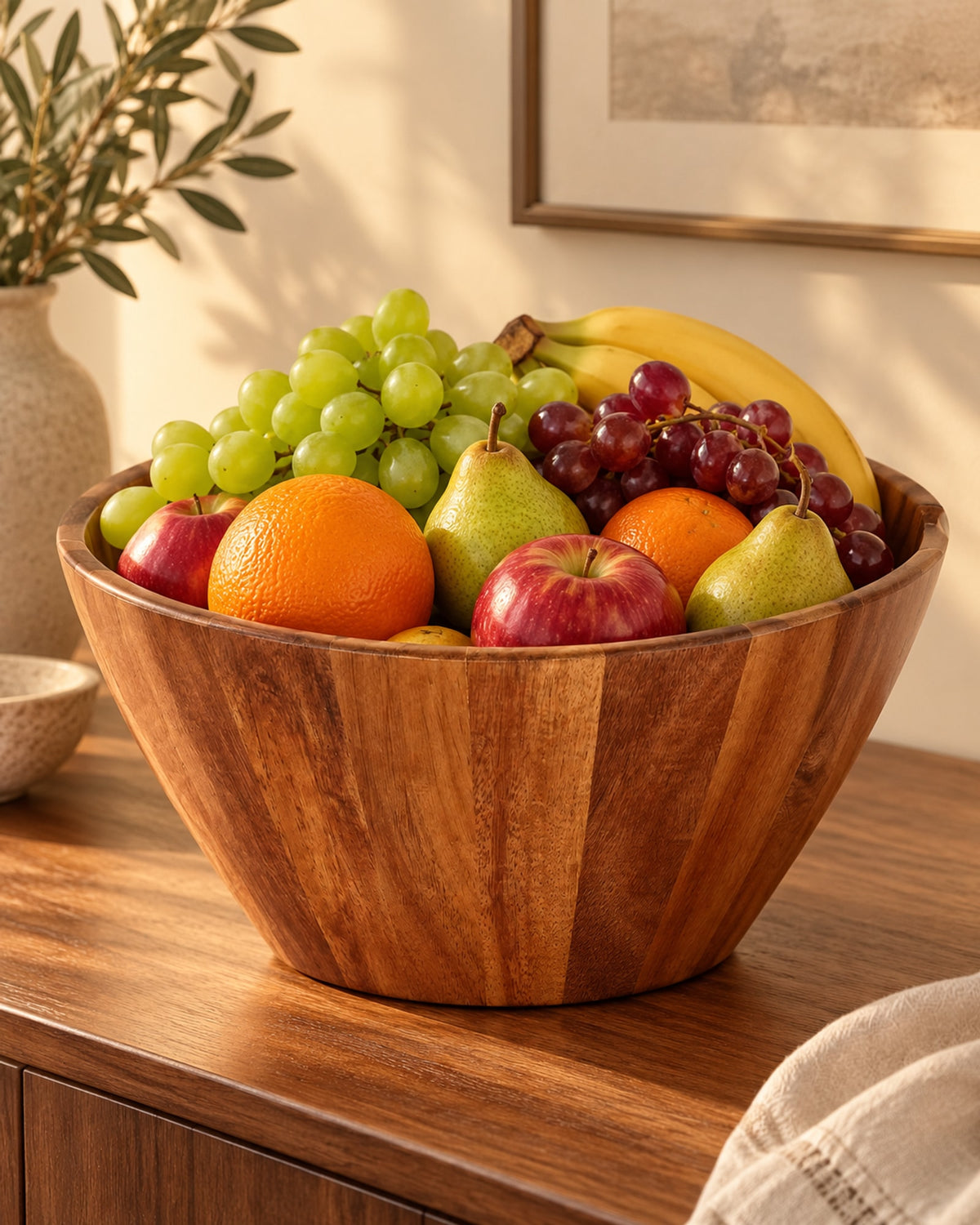 Acacia bowl filled with fruit on a sideboard in evening light. Fruit not included.
