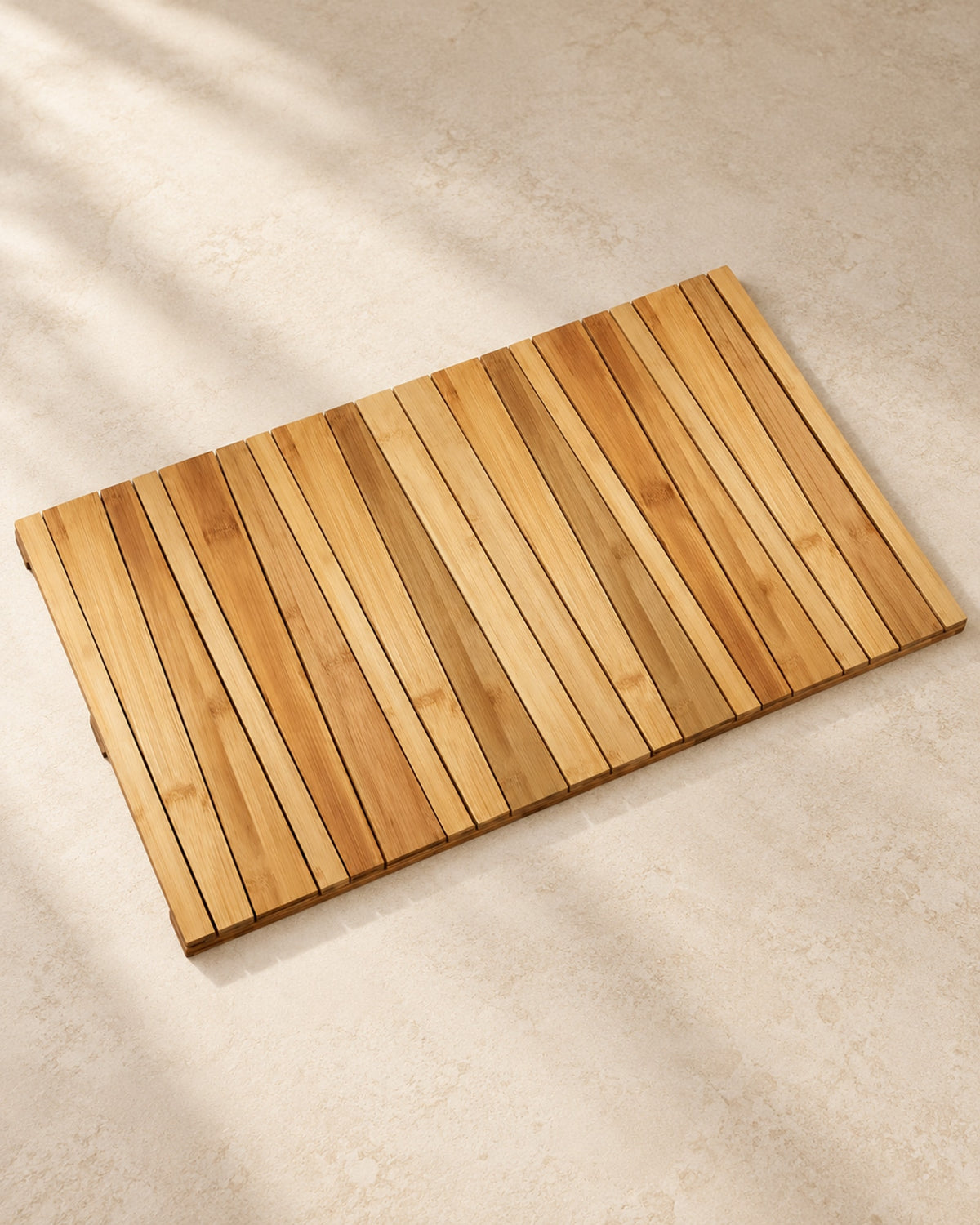 Slatted bamboo bath mat on a warm off-white floor.