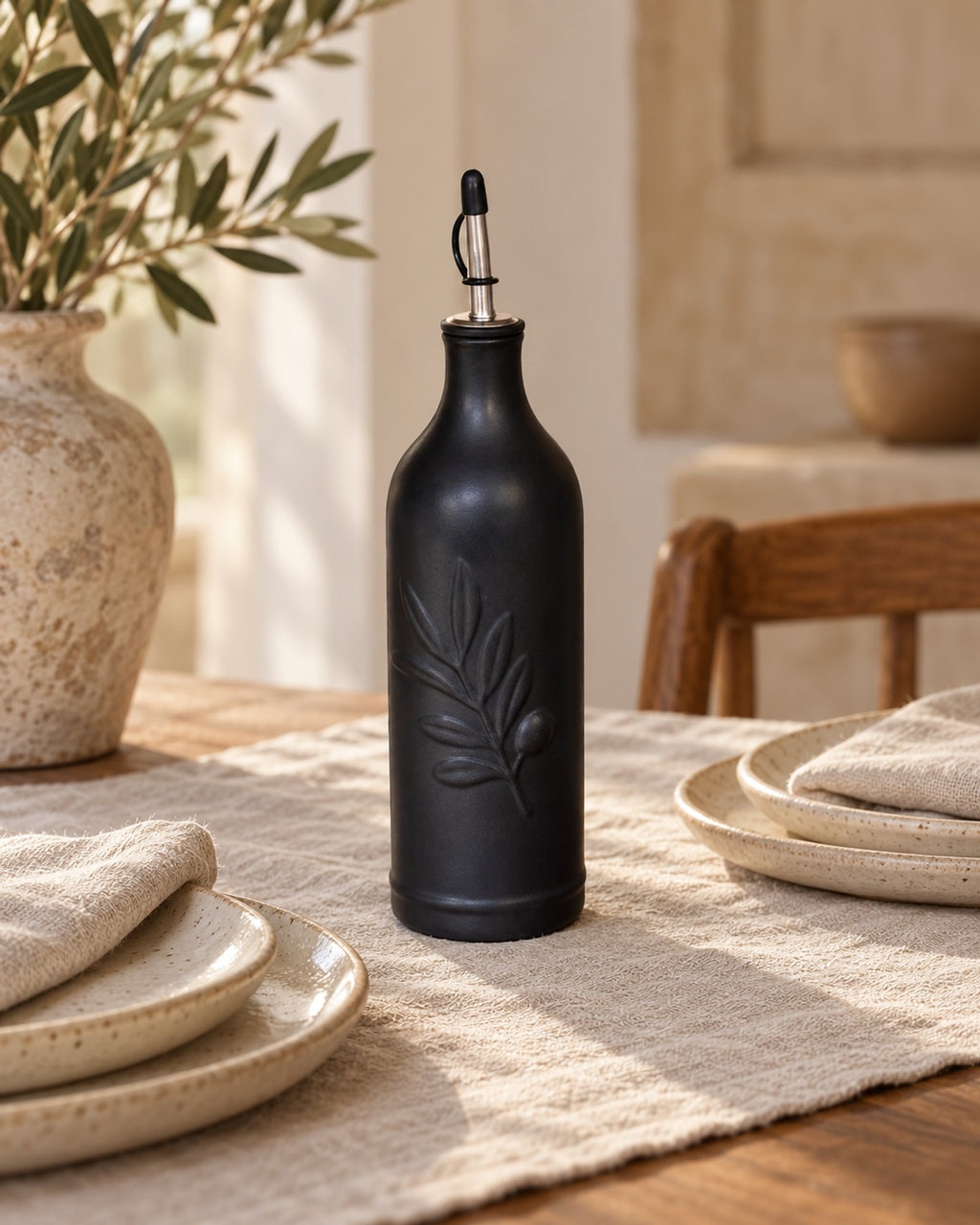 Black ceramic oil bottle on a dining table set for two.