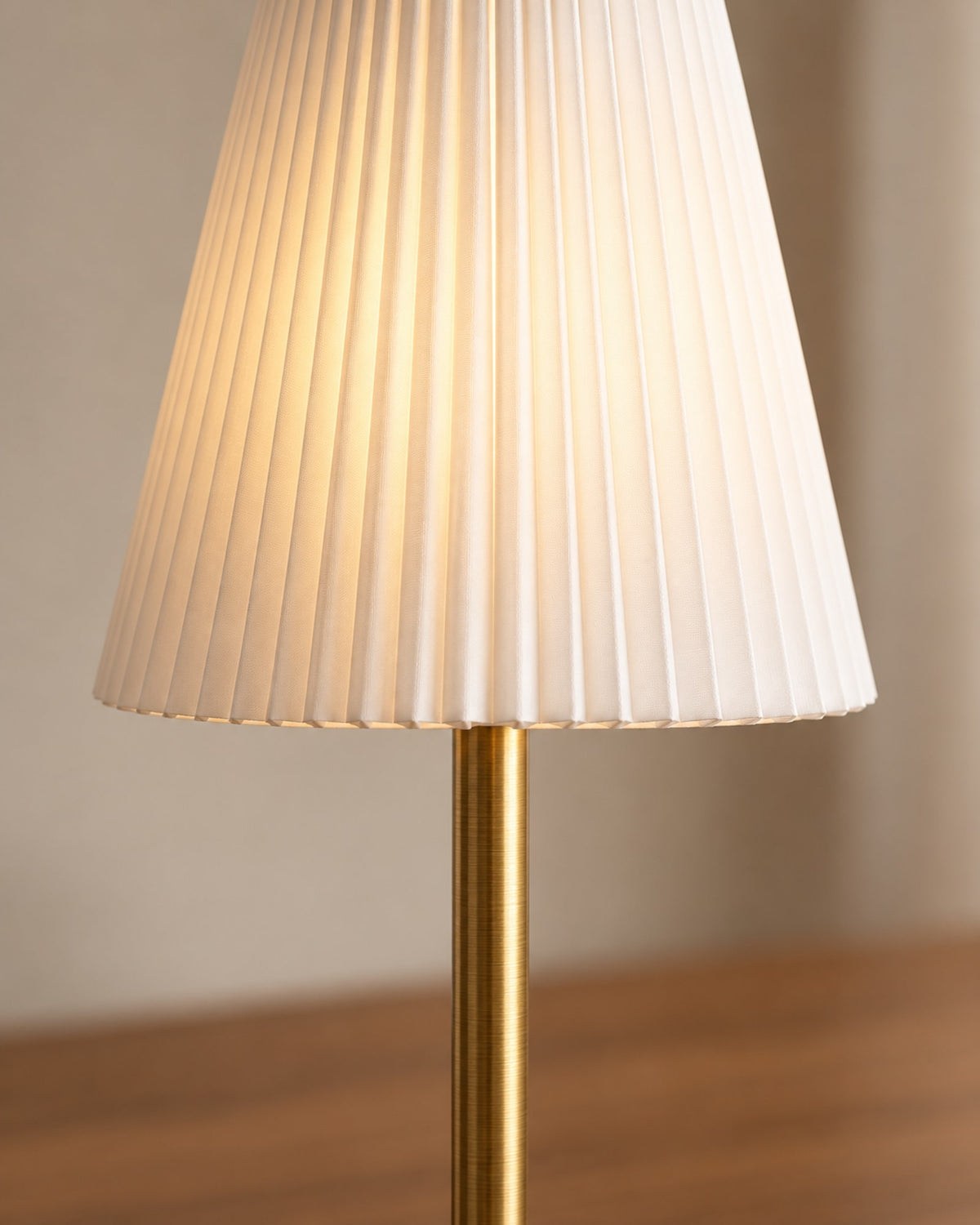 Close-up of the pleated fabric shade and brass-coloured stem.