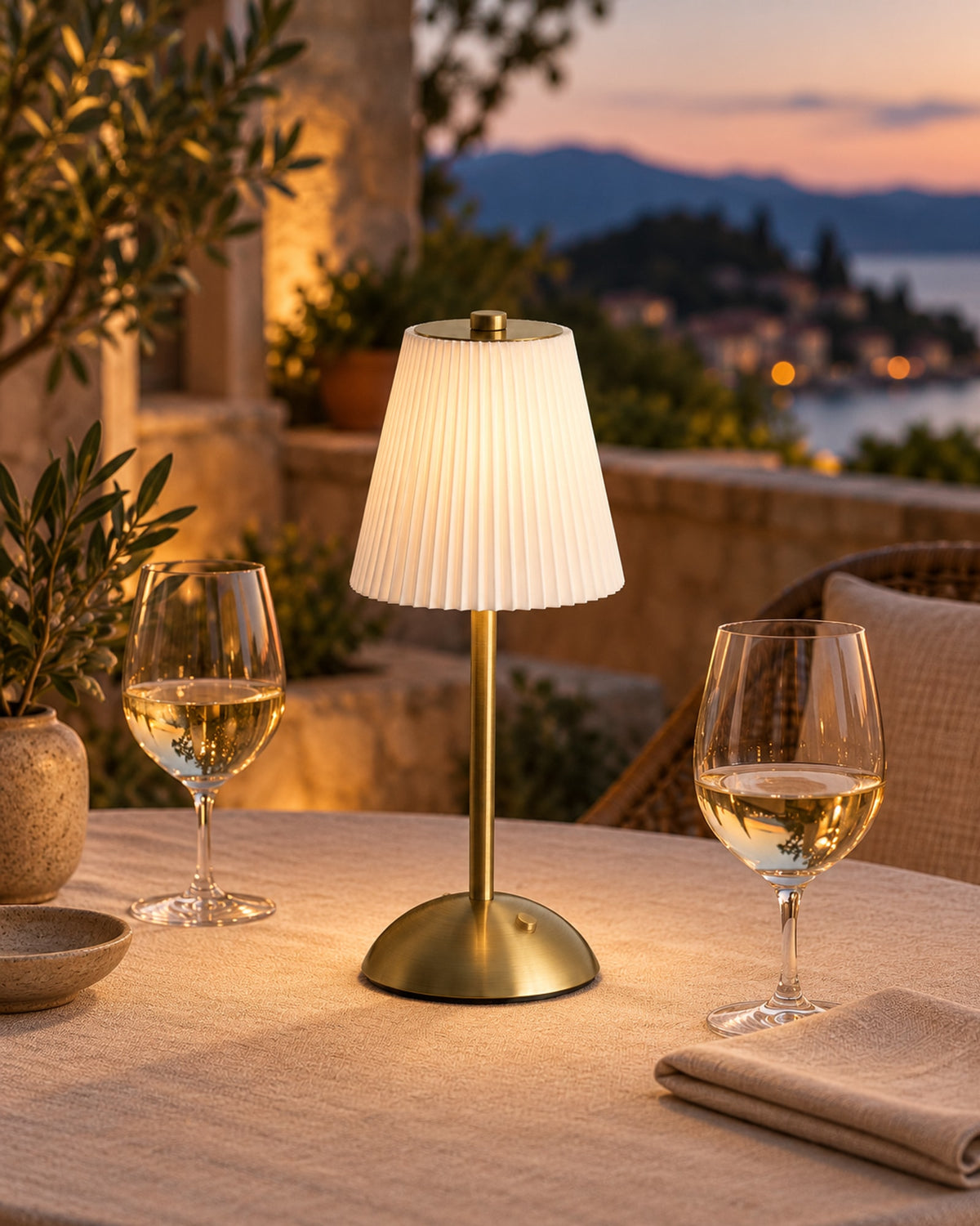 Cordless pleated lamp on a terrace dining table at dusk.