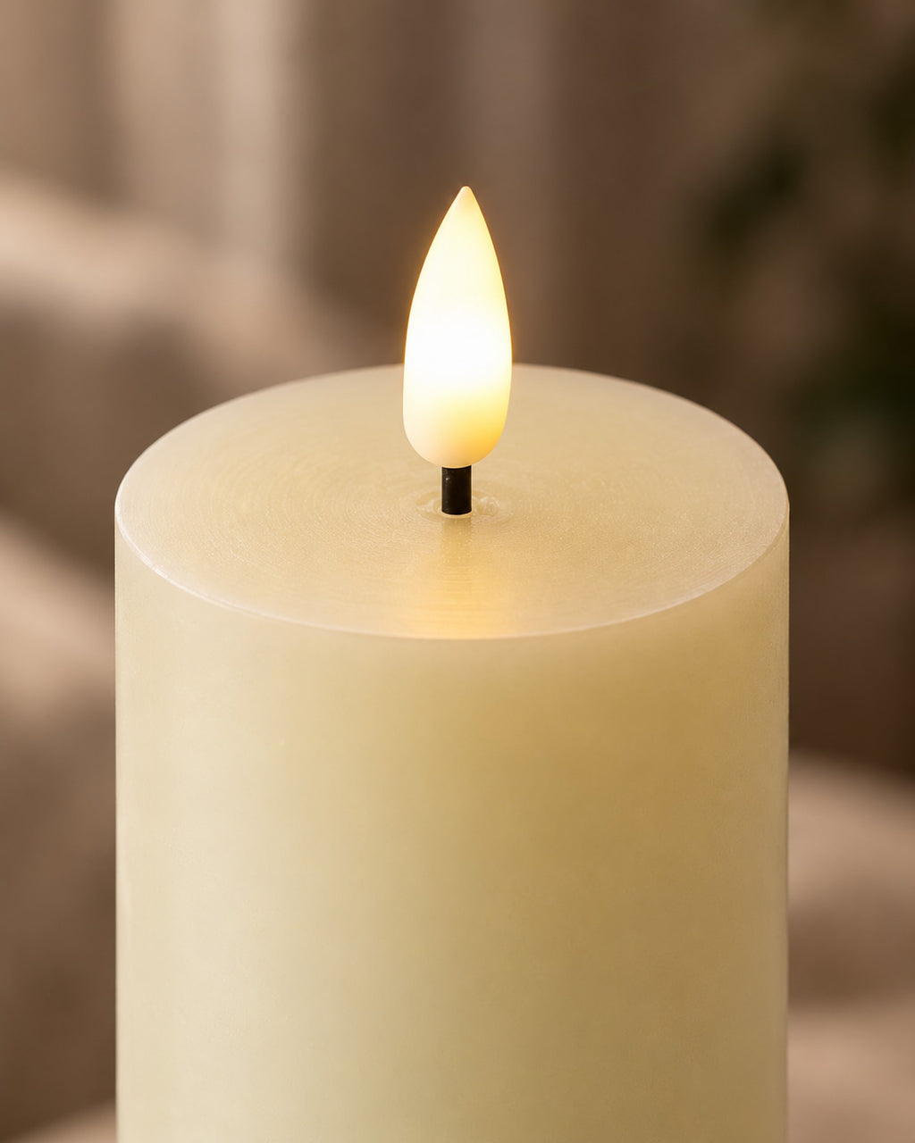 Close-up of the flame-shaped LED on top of an ivory wax candle.