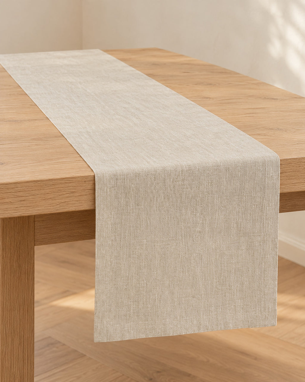 Champagne linen table runner along a light oak dining table.