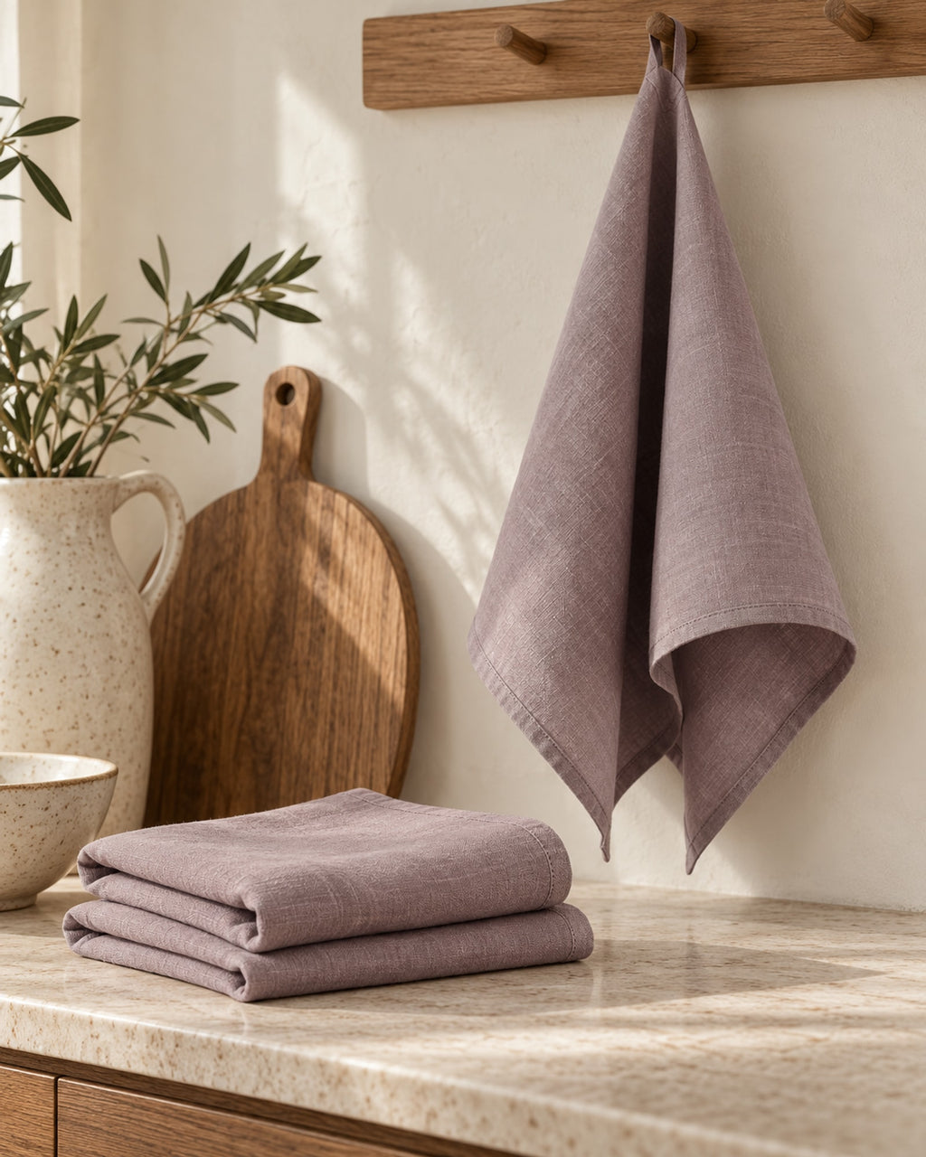 Linen tea towel hanging from an oak rail in a calm kitchen.