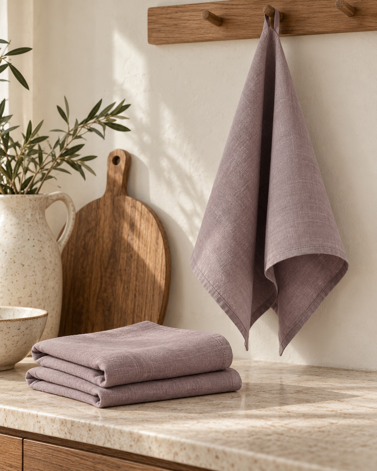Linen tea towel hanging from an oak rail in a calm kitchen.