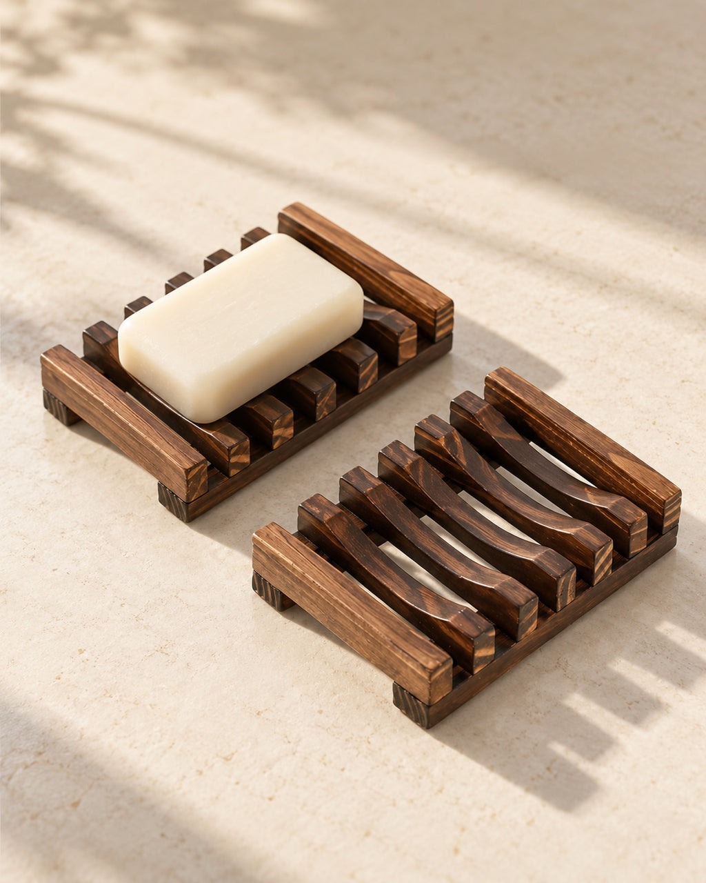 Two dark wooden slatted soap dishes, one with a cream soap bar. Soap not included.