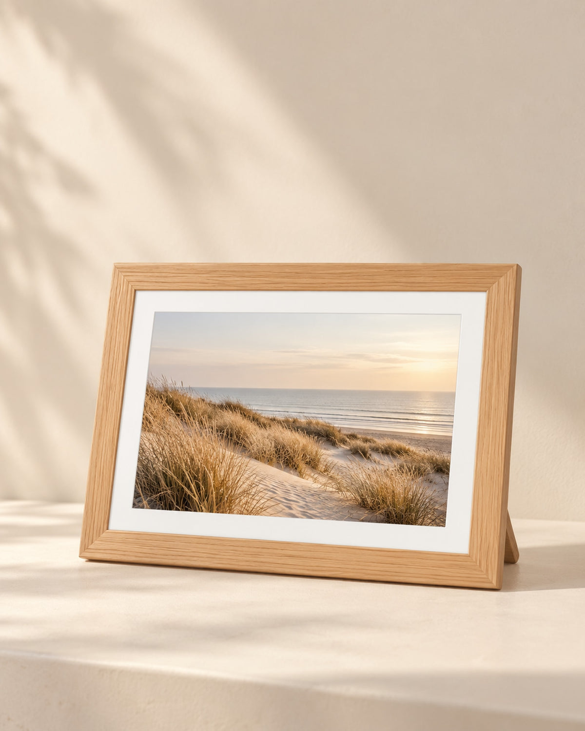 Wooden 10.1-inch Wi-Fi photo frame with a white mat showing a dune landscape.